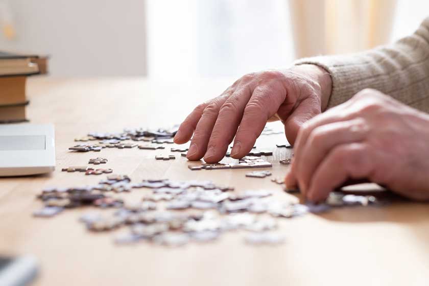 senior male hands working on a puzzle