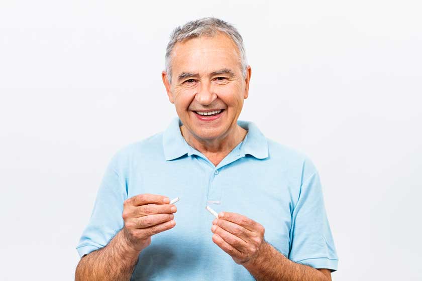 senior man breaking cigarette