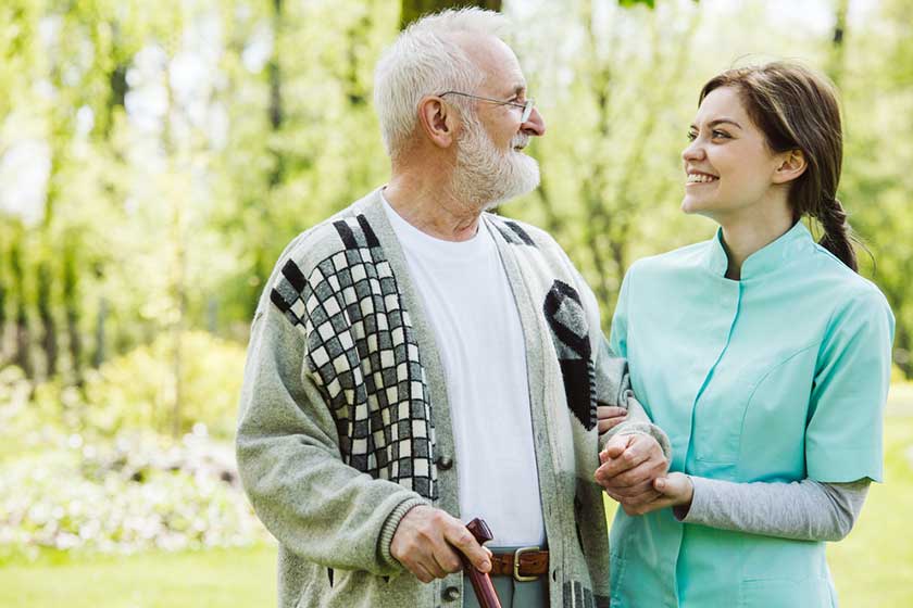 senior man with helpful volunteer in the garden