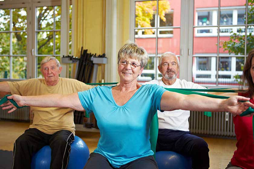 seniorengruppe trainiert mit latexband