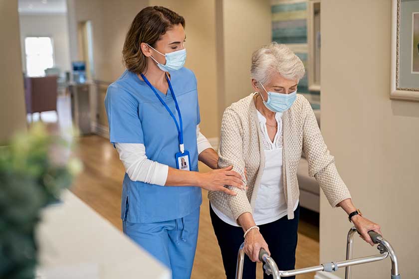 smiling nurse face mask helping senior woman smiling nurse face mask helping senior woman