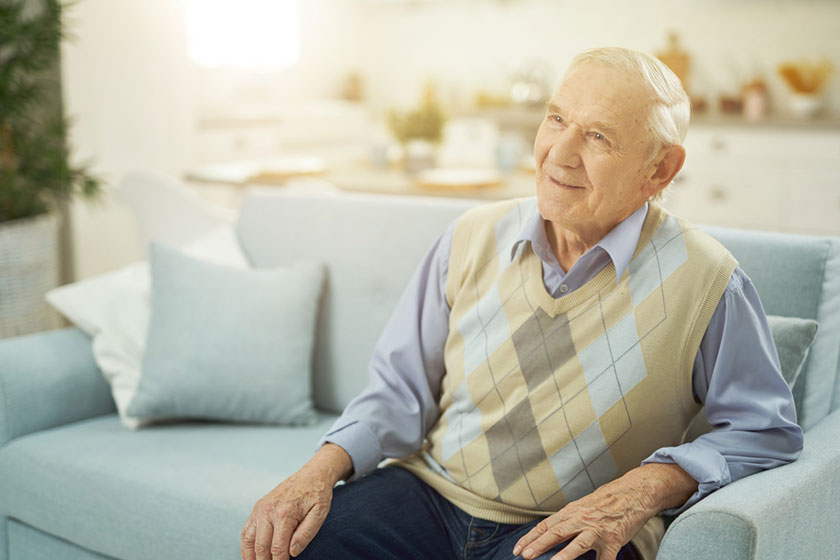 smiling retired man sitting on sofa