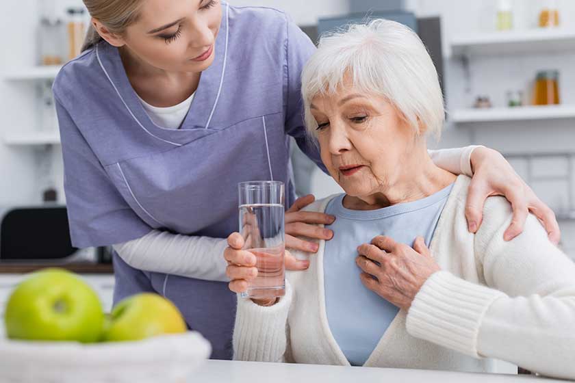 social worker hugging shoulders aged woman