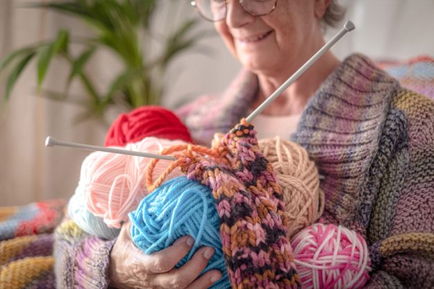 caucasian senior woman at home holding in her hands wool balls