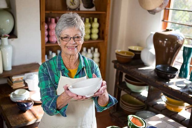 female potter holding bowl female potter holding bowl