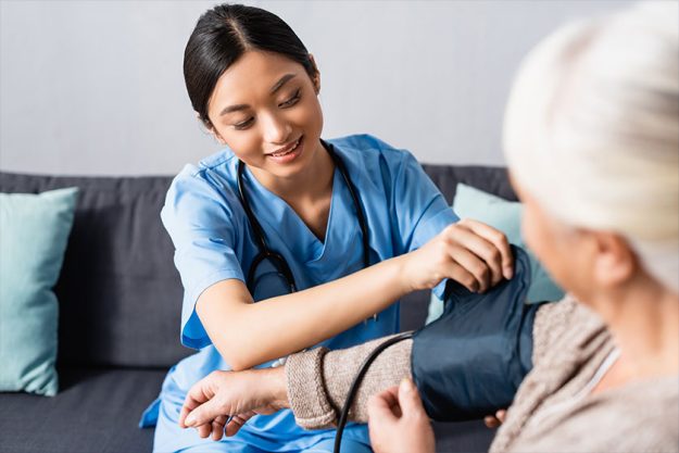 nurse fixing cuff tonometer arm aged woman hospital