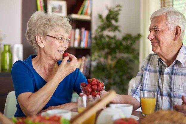 senior couple eating strawberries senior couple eating strawberries