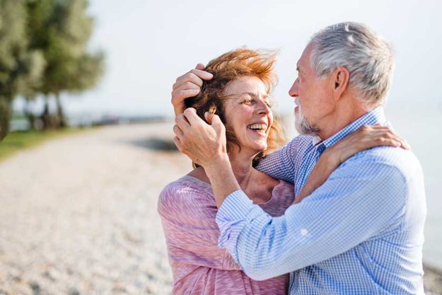 senior couple on a holiday on a walk by the lake senior couple on a holiday on a walk by the lake