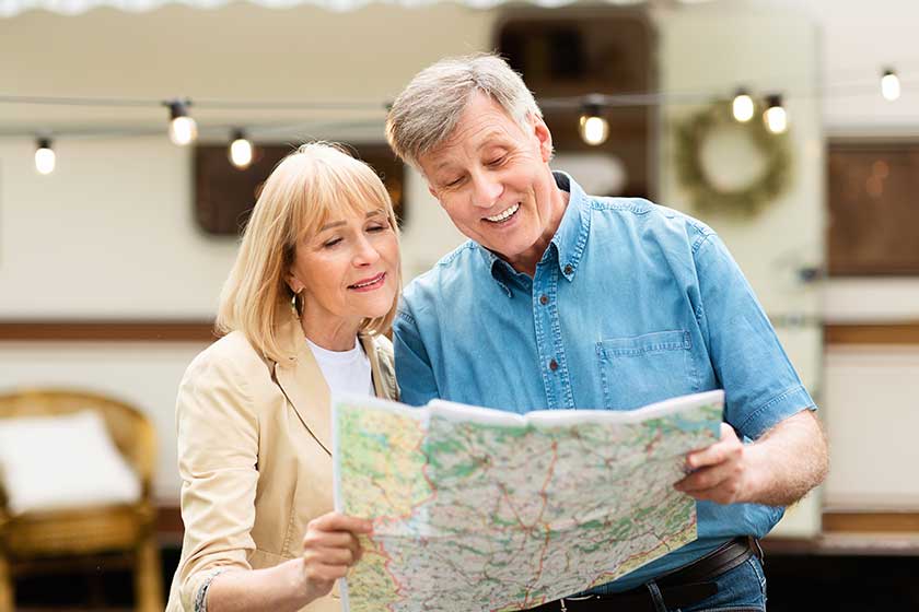 senior man and his wife reading map together