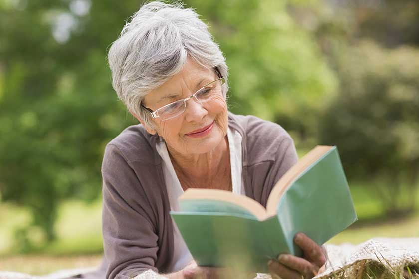 senior woman reading a book at park senior woman reading a book at park