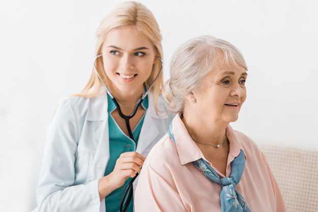 young smiling female doctor examining stethoscope senior woman young smiling female doctor examining stethoscope senior woman