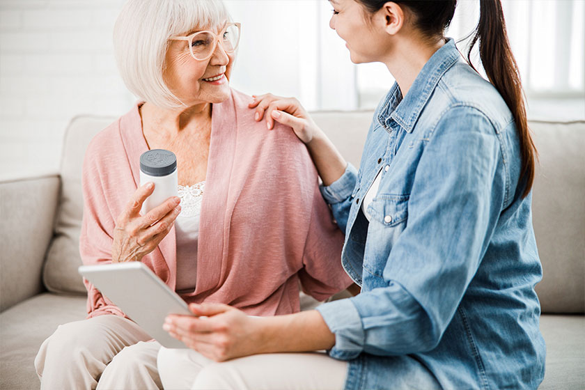 family doctor recommending medicaments to old woman