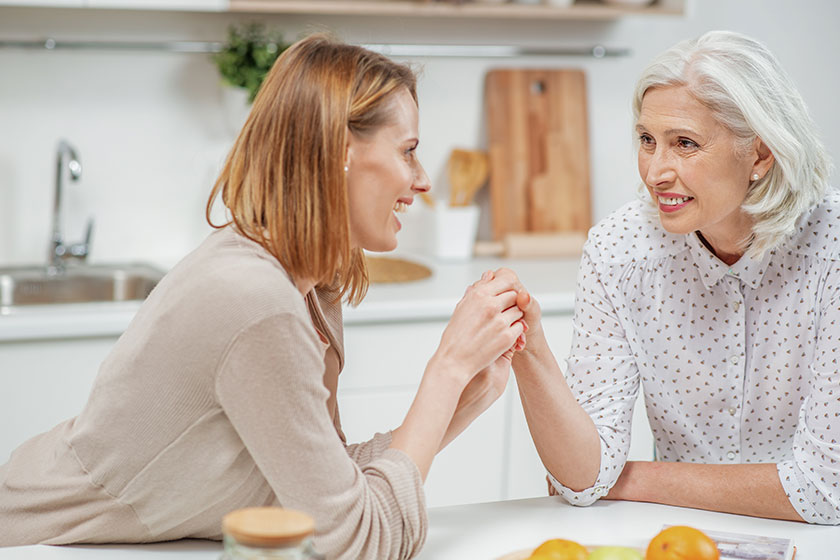 happy young woman holding hand of her mother