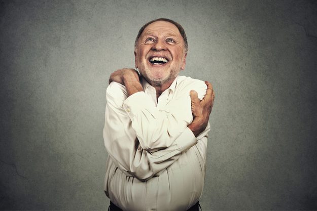 smiling man holding hugging himself