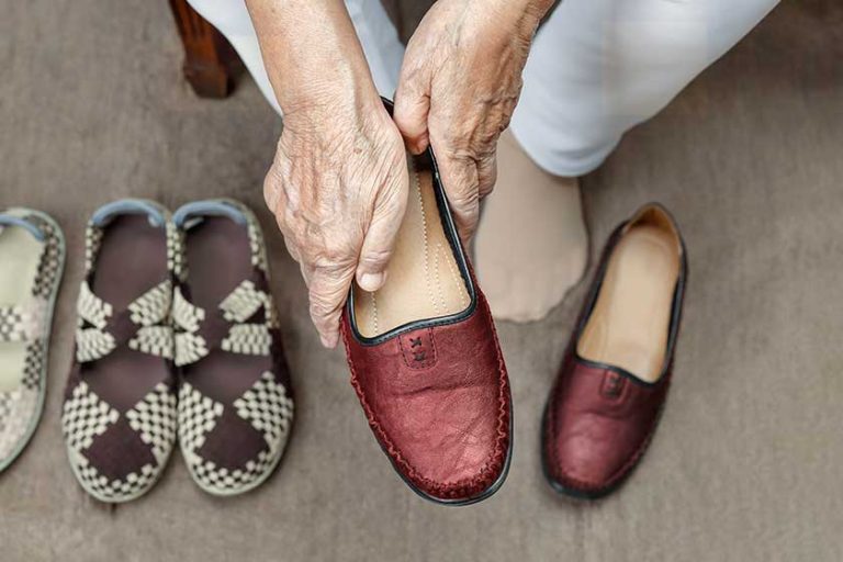 elderly woman putting on shoes