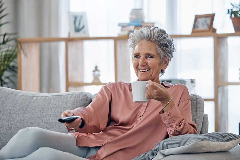 Senior woman sofa and coffee to relax with remote Senior woman sofa and coffee to relax with remote