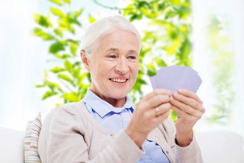 happy senior woman playing cards