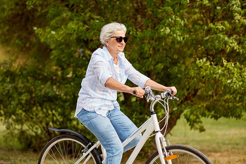 happy senior woman riding bicycle