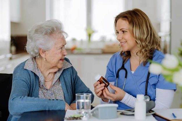 nurse giving pills senior woman