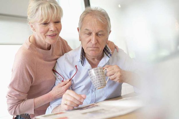 senior couple reading newspaper