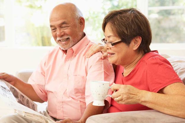 senior couple reading newspaper home