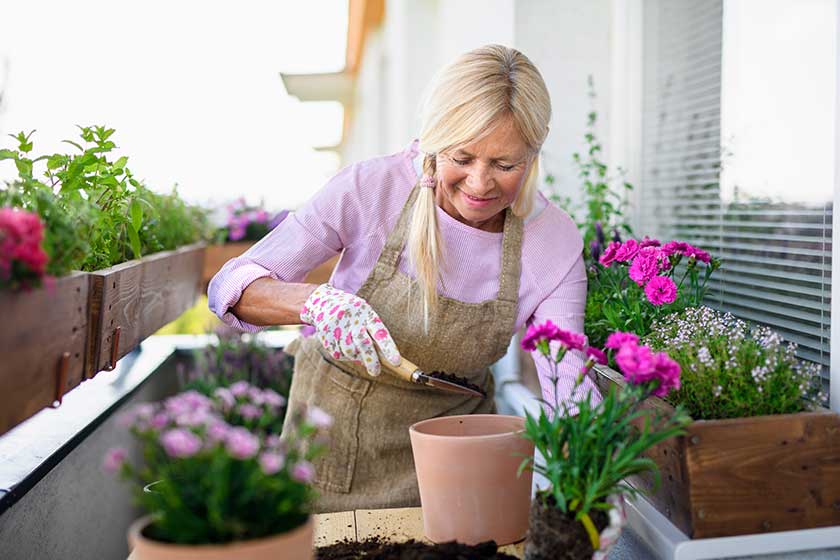 senior woman gardening on balcony