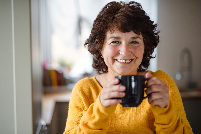senior woman with cup of coffee at home relaxing