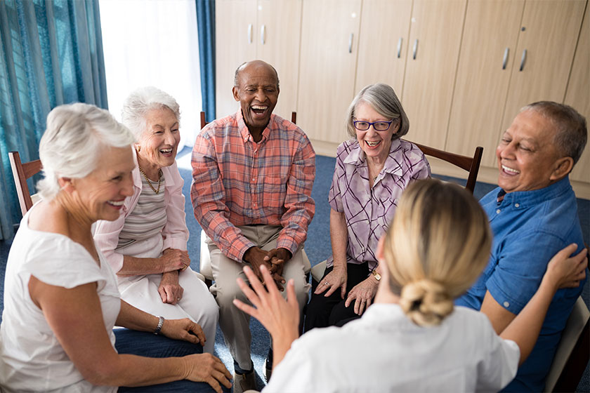 seniors sitting with female doctor on chairs seniors sitting with female doctor on chairs