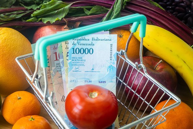venezuelan money shopping cart vegetables fruits concept growing food prices