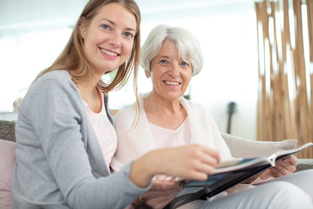 elderly woman daughter checking album