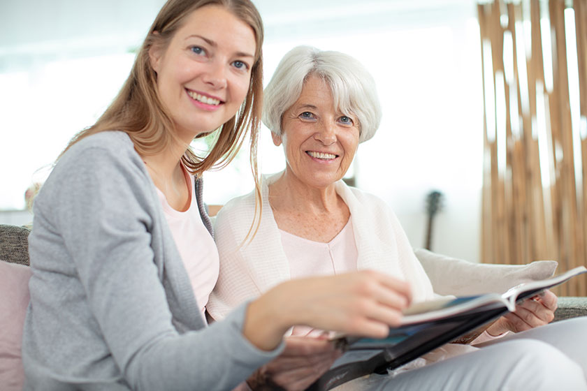 elderly woman daughter checking album elderly woman daughter checking album