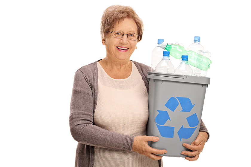 happy mature woman holding recycling
