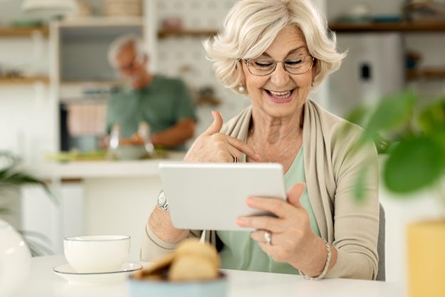 happy mature woman using digital