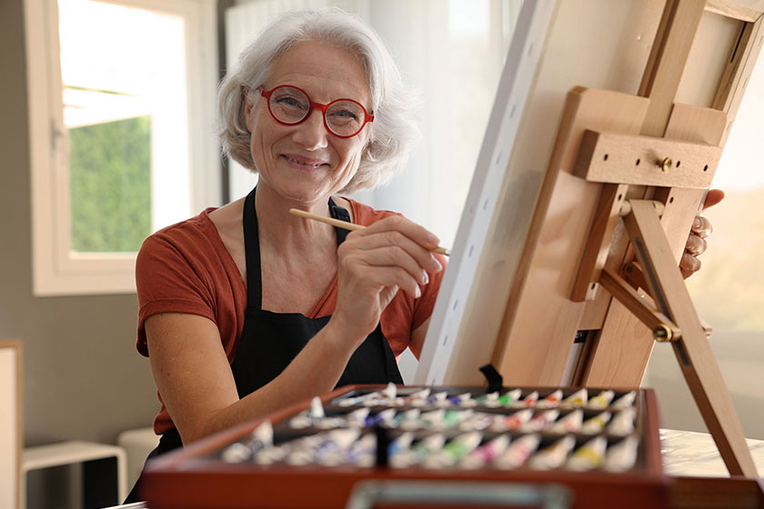 senior woman painting canvas senior woman painting canvas