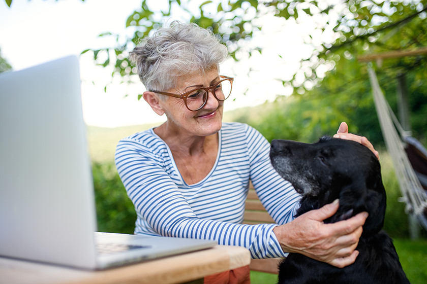 senior woman with laptop and dog