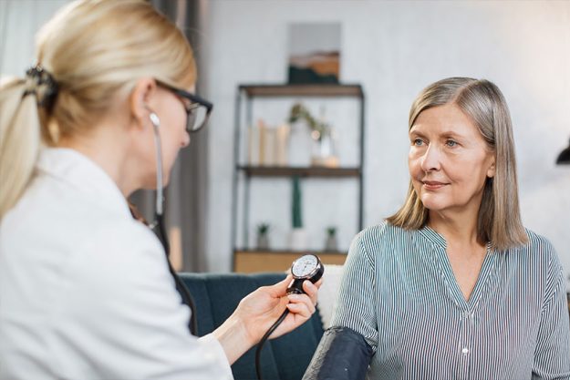 close up photo of blood pressure measurement blurred view of female nurse close up photo of blood pressure measurement blurred view of female nurse