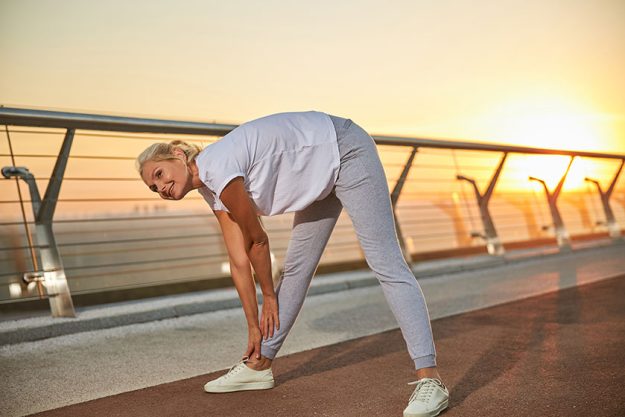 high spirited caucasian female athlete warming up outdoors