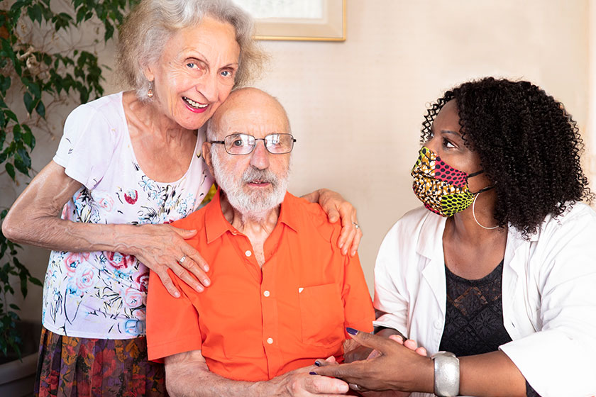 horizontal portrait african american medical assistant helping ederly couple home