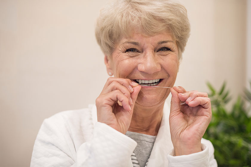 mature woman with dental floss