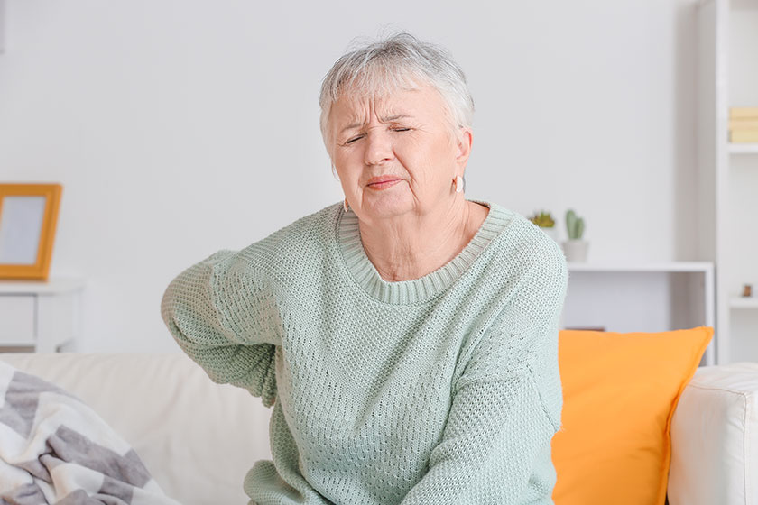 senior woman suffering from back pain at home senior woman suffering from back pain at home