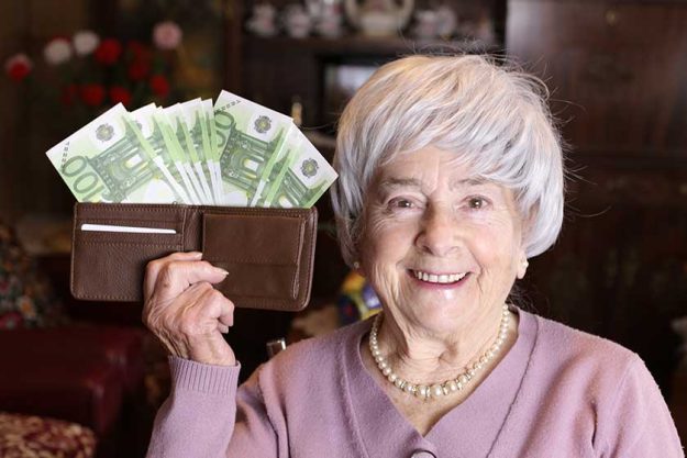 close portrait mature woman holding wallet full cash home