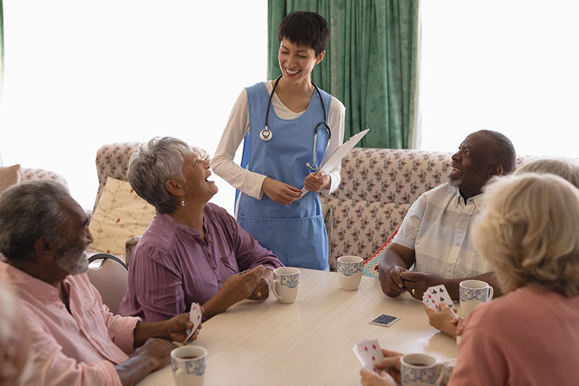 front view female doctor interacting senior people while playing card 1