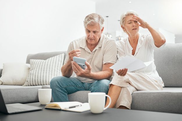 frustrated senior couple documents debt living room sofa financial crisis frustrated senior couple documents debt living room sofa financial crisis