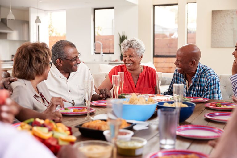 grandfather making toast dinner table celebrating his family