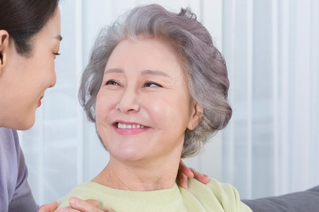 happy smiling asian old mother middle aged daughter sofa