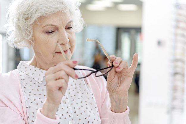 interested old woman choosing eyewear interested old woman choosing eyewear