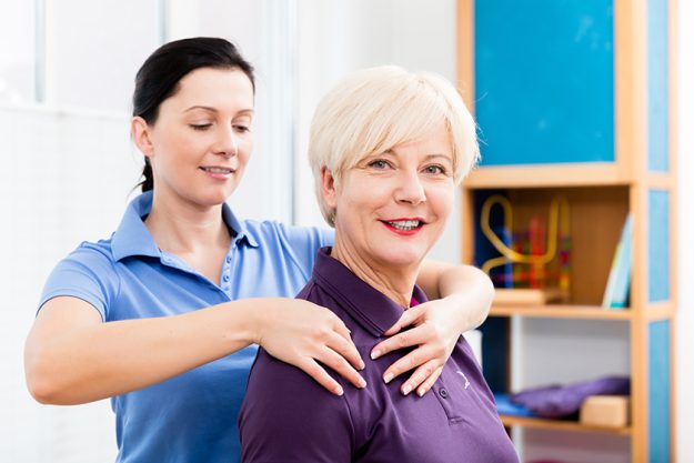 masseuse applying neck massage on older woman masseuse applying neck massage on older woman
