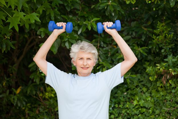 mature woman doing her exercises in the garden mature woman doing her exercises in the garden