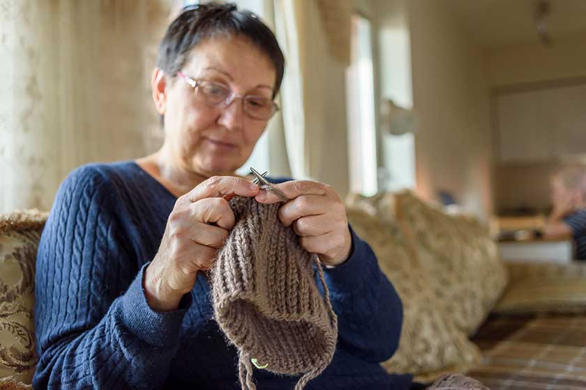 mature woman knitting hat relaxing