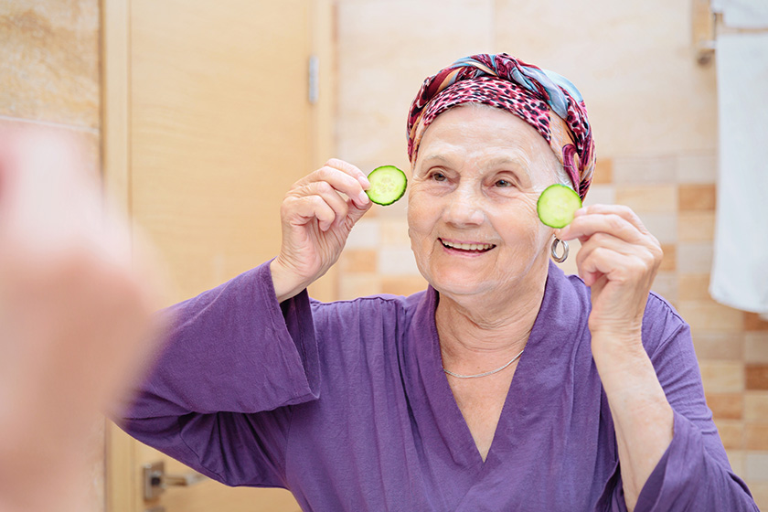 mature woman taking care her face senior woman standing mirror